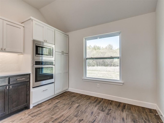 1241 SW 139th St, Oklahoma City, OK 73170 - kitchen featuring appliances with stainless steel finishes, vaulted ceiling, wood finished floors, light countertops, and baseboards