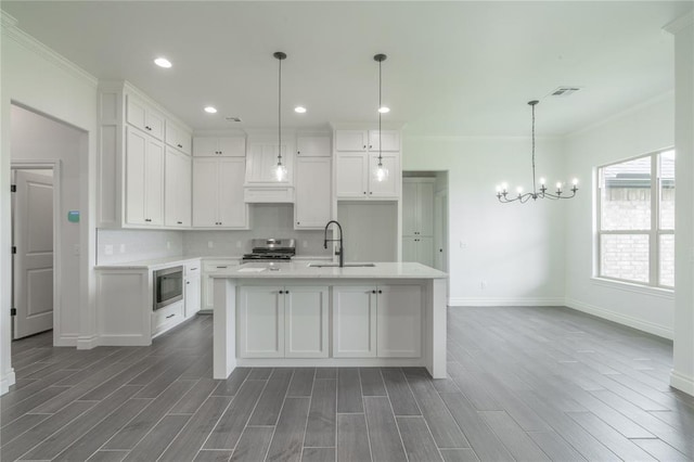 9217 SW 43rd St, Oklahoma City, OK 73179 - kitchen featuring stove, stainless steel microwave, a sink, baseboards, and white cabinetry