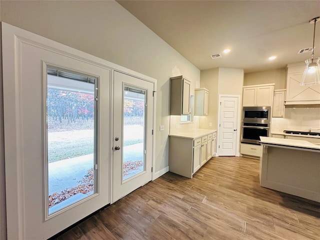 1233 SW 139th St, Oklahoma City, OK 73170 - kitchen featuring appliances with stainless steel finishes, light countertops, decorative backsplash, light wood-type flooring, and recessed lighting