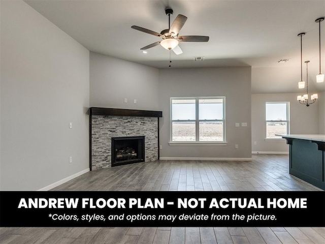 8600 NW 75th St, Oklahoma City, OK 73132 - unfurnished living room with wood finished floors, ceiling fan, a chandelier, a stone fireplace, and baseboards