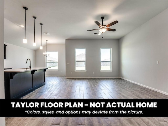 8509 NW 76th St, Oklahoma City, OK 73132 - kitchen with wood finished floors, ceiling fan, baseboards, a sink, and pendant lighting