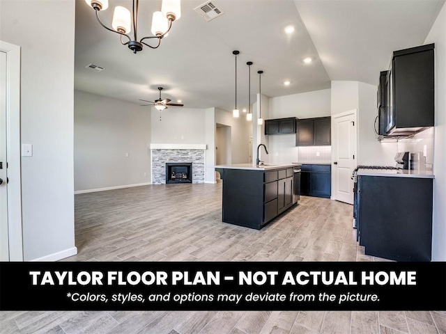 8509 NW 76th St, Oklahoma City, OK 73132 - kitchen featuring a sink, a ceiling fan, light wood-type flooring, light countertops, and a kitchen island with sink