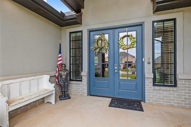4813 Hambletonian Ln, Mustang, OK 73064 - property entrance featuring french doors, stucco siding, a patio, and brick siding