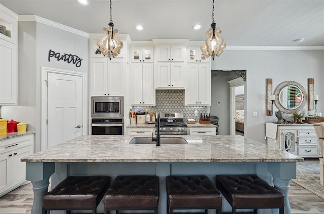 4813 Hambletonian Ln, Mustang, OK 73064 - kitchen with appliances with stainless steel finishes, a sink, a kitchen bar, tasteful backsplash, and ornamental molding