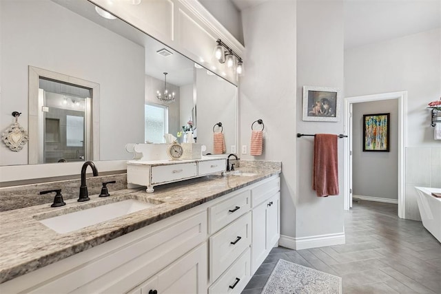 4813 Hambletonian Ln, Mustang, OK 73064 - full bath featuring double vanity, a freestanding bath, baseboards, and a chandelier
