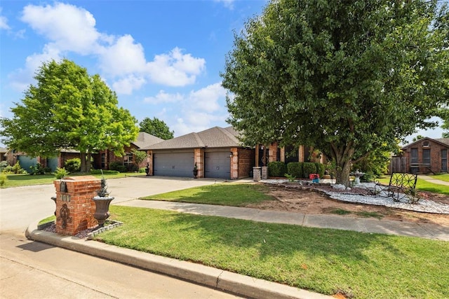 704 N Geronimo Way, Mustang, OK 73064 - view of front of property featuring an attached garage, a front lawn, concrete driveway, and brick siding