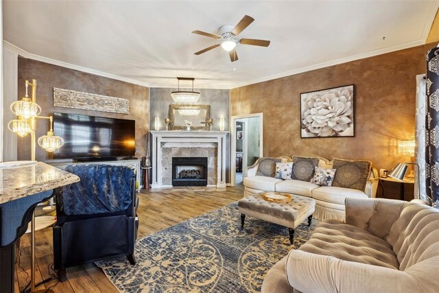 704 N Geronimo Way, Mustang, OK 73064 - living area featuring ceiling fan, wood finished floors, a tiled fireplace, and crown molding