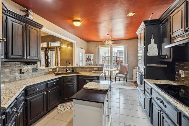 704 N Geronimo Way, Mustang, OK 73064 - kitchen with black appliances, light tile patterned floors, backsplash, a kitchen island, and a peninsula