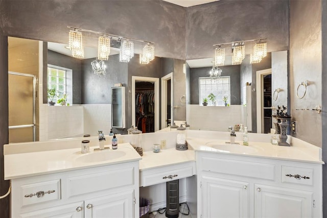 704 N Geronimo Way, Mustang, OK 73064 - full bathroom with a chandelier, double vanity, a spacious closet, and a shower stall