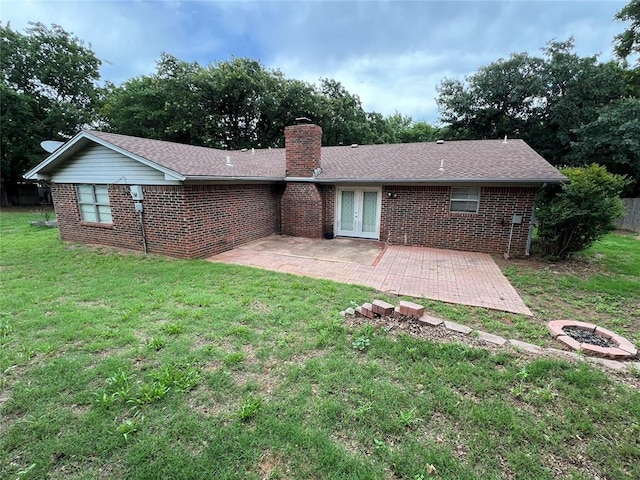 3014 S Mission St, Anadarko, OK 73005 - rear view of house with a chimney, a patio, brick siding, a lawn, and an outdoor fire pit