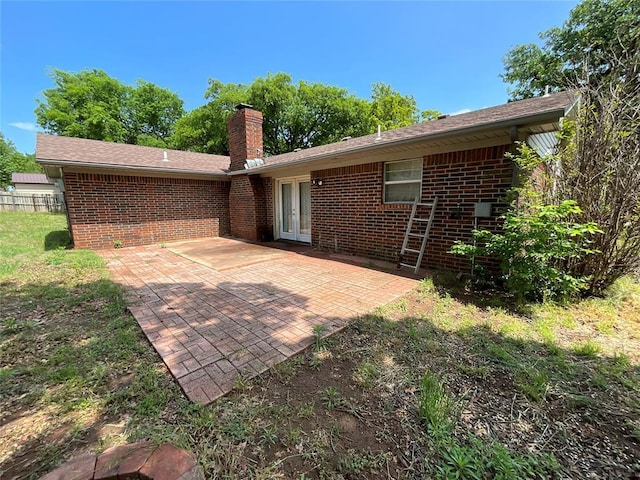 3014 S Mission St, Anadarko, OK 73005 - back of house featuring a chimney, a patio, brick siding, and french doors
