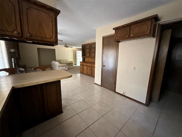 3014 S Mission St, Anadarko, OK 73005 - kitchen with a ceiling fan, light tile patterned floors, a kitchen breakfast bar, light countertops, and open floor plan