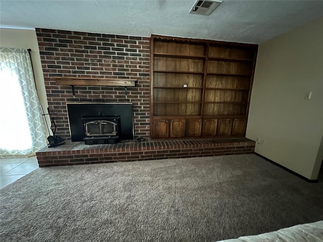 3014 S Mission St, Anadarko, OK 73005 - unfurnished living room featuring a wood stove, carpet flooring, built in features, and tile patterned floors