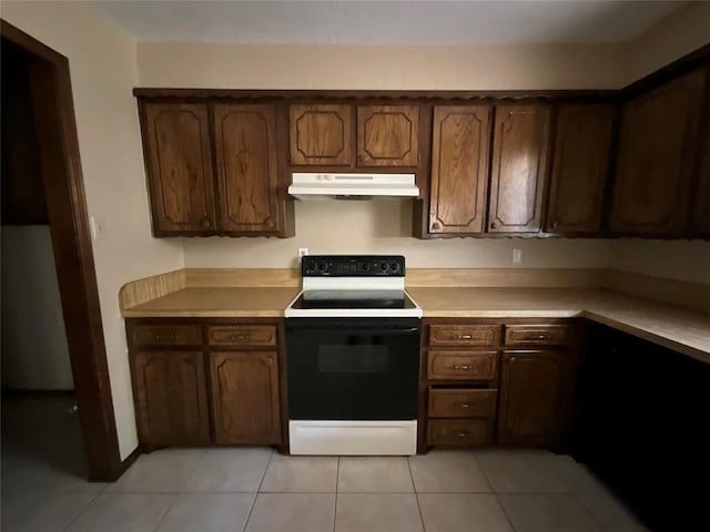 3014 S Mission St, Anadarko, OK 73005 - kitchen with electric range oven, under cabinet range hood, light countertops, and light tile patterned floors