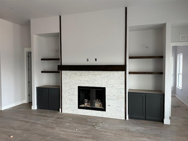 10109 NW 100th St, Yukon, OK 73099 - unfurnished living room featuring wood finished floors, baseboards, and a fireplace