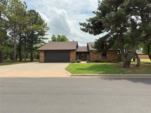2308 Lynn Ln, Weatherford, OK 73096 - view of front of property featuring an attached garage, driveway, brick siding, and a front lawn