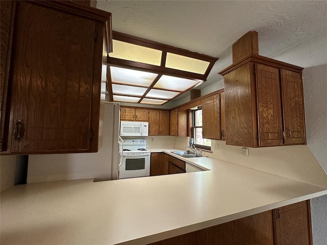 2308 Lynn Ln, Weatherford, OK 73096 - kitchen featuring white appliances, a sink, light countertops, a peninsula, and a textured ceiling