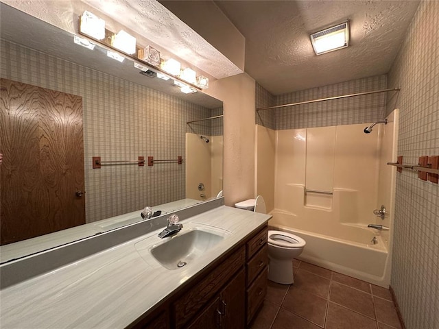 2308 Lynn Ln, Weatherford, OK 73096 - bathroom featuring toilet, vanity, washtub / shower combination, tile patterned floors, and a textured ceiling