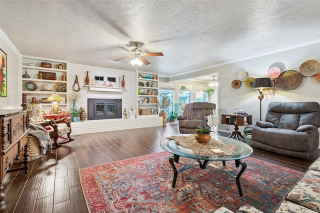 106 Dee Dee Dr, Shawnee, OK 74804 - living area featuring a ceiling fan, a textured ceiling, ornamental molding, wood finished floors, and a fireplace