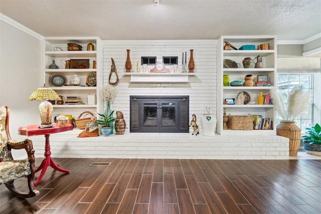 106 Dee Dee Dr, Shawnee, OK 74804 - living area featuring wood finished floors, ornamental molding, a brick fireplace, and a textured ceiling