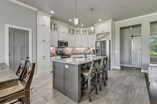 2383 Fox Ln, Blanchard, OK 73010 - kitchen featuring appliances with stainless steel finishes, a sink, a barn door, tasteful backsplash, and recessed lighting