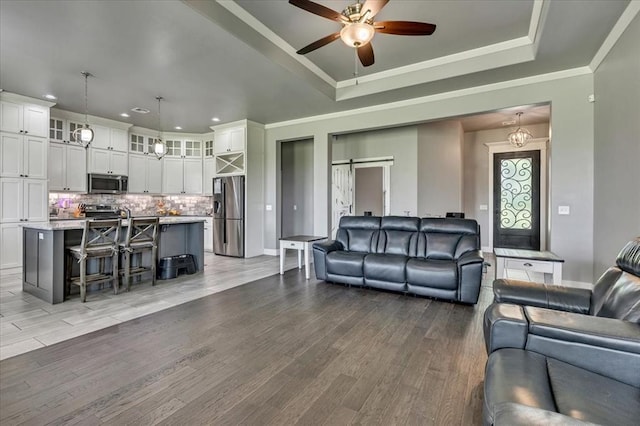 2383 Fox Ln, Blanchard, OK 73010 - living room with a ceiling fan, light wood finished floors, recessed lighting, a raised ceiling, and ornamental molding