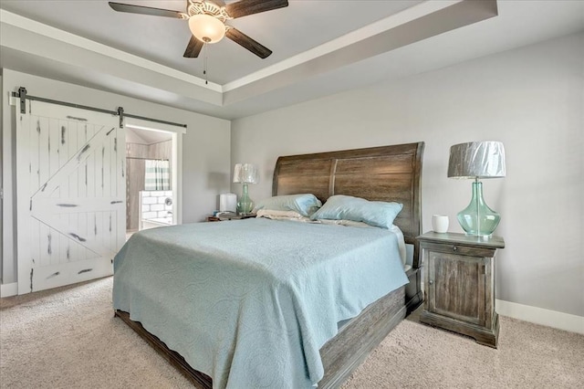 2383 Fox Ln, Blanchard, OK 73010 - bedroom featuring carpet, a raised ceiling, baseboards, a barn door, and a ceiling fan