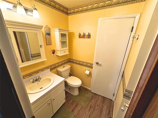 900 Hairston St, Altus, OK 73521 - bathroom with wood finished floors, toilet, and vanity
