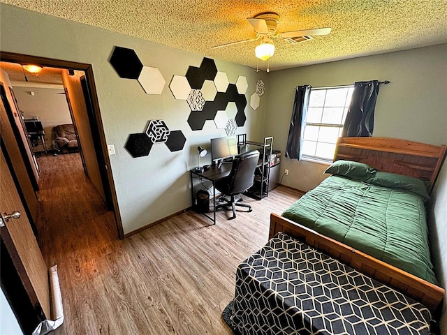 900 Hairston St, Altus, OK 73521 - bedroom with light wood-style floors, an office area, a textured ceiling, and baseboards