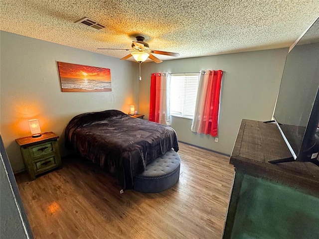 900 Hairston St, Altus, OK 73521 - bedroom with wood finished floors, a textured ceiling, and ceiling fan