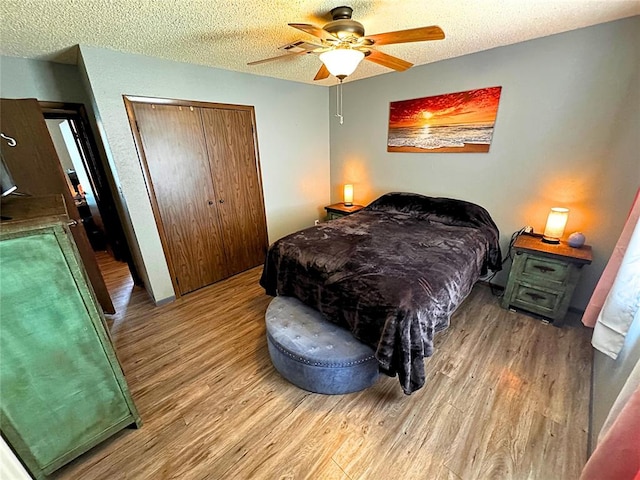 900 Hairston St, Altus, OK 73521 - bedroom featuring wood finished floors, a closet, a textured ceiling, and a ceiling fan