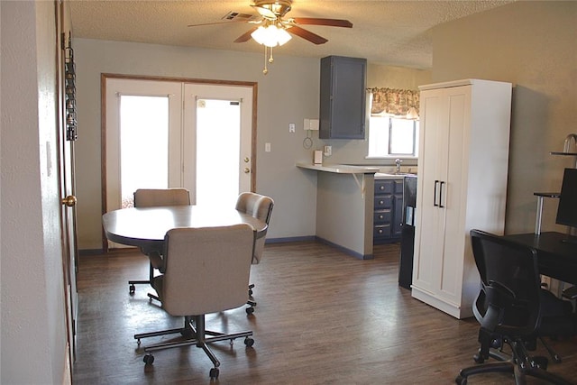 900 Hairston St, Altus, OK 73521 - dining area featuring dark wood-style flooring, ceiling fan, a textured ceiling, a desk, and baseboards