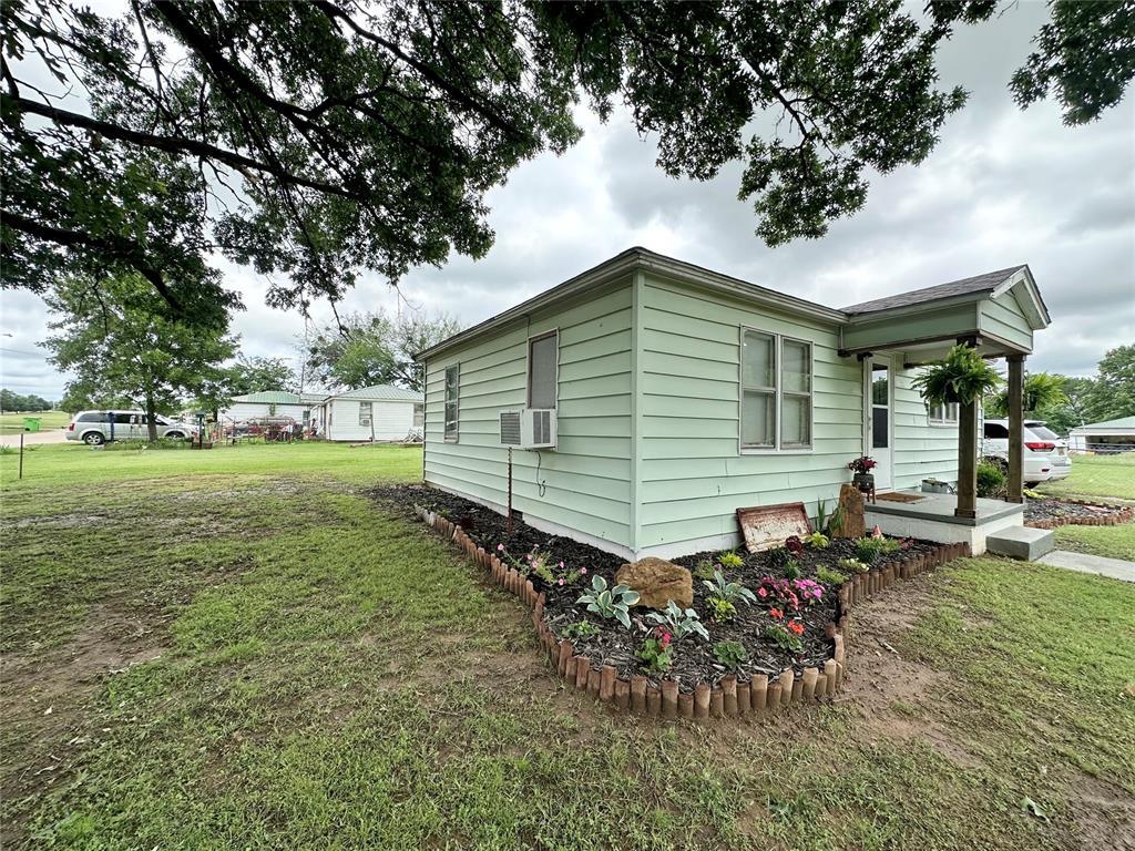422 E 11th St, Prague, OK 74864 - view of property exterior with a lawn and cooling unit