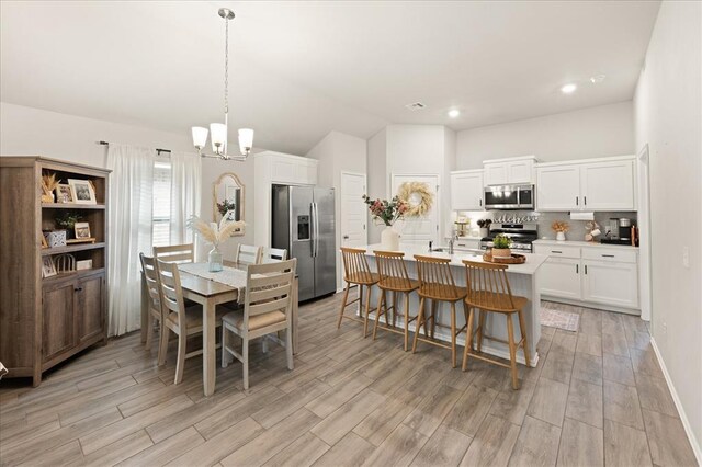 19908 Taggert Dr, Edmond, OK 73012 - dining space with a chandelier, light wood-style flooring, lofted ceiling, recessed lighting, and baseboards