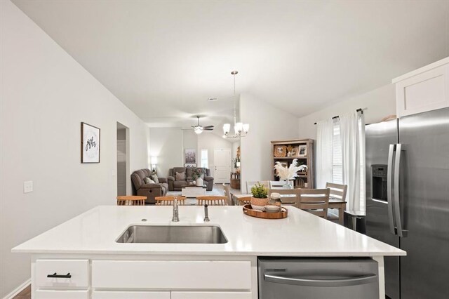 19908 Taggert Dr, Edmond, OK 73012 - kitchen with stainless steel appliances, open floor plan, lofted ceiling, light countertops, and a chandelier