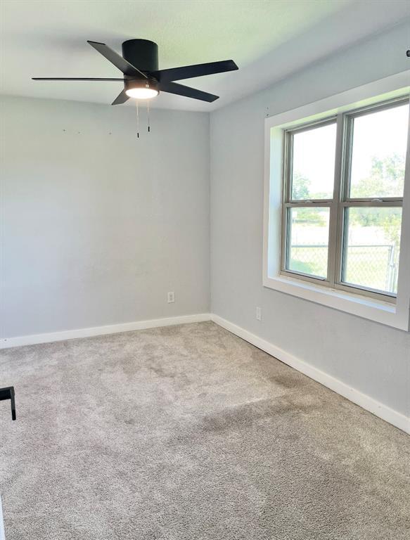 1304 W Walnut St, Tecumseh, OK 74873 - carpeted empty room featuring a ceiling fan and baseboards