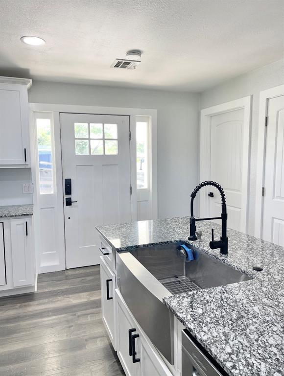 1304 W Walnut St, Tecumseh, OK 74873 - kitchen with light wood finished floors, white cabinets, stone countertops, recessed lighting, and dishwasher