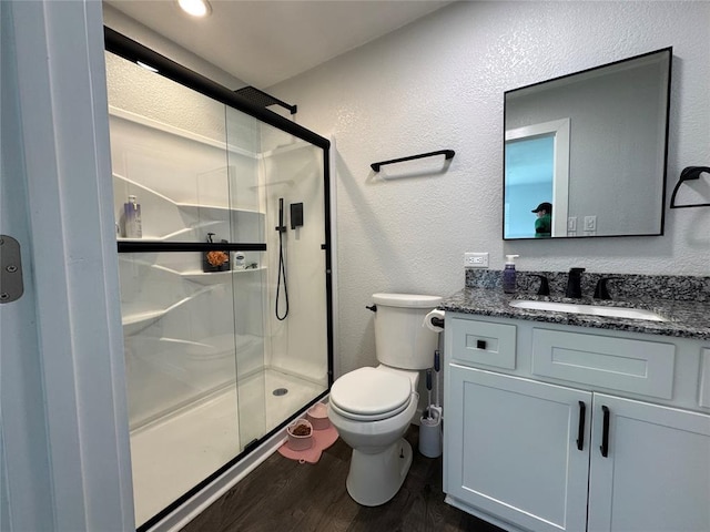 1304 W Walnut St, Tecumseh, OK 74873 - bathroom featuring a textured wall, a shower stall, wood finished floors, and vanity