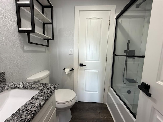 1304 W Walnut St, Tecumseh, OK 74873 - full bathroom featuring vanity, wood finished floors, shower / bath combination with glass door, and a textured wall