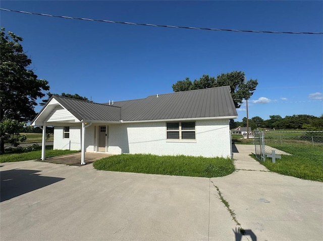 1304 W Walnut St, Tecumseh, OK 74873 - view of front facade with a metal roof and brick siding