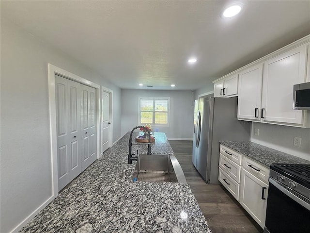 1304 W Walnut St, Tecumseh, OK 74873 - kitchen with white cabinetry, dark stone countertops, stainless steel appliances, recessed lighting, and dark wood-style floors