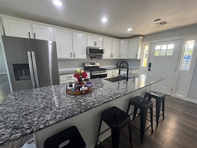 1304 W Walnut St, Tecumseh, OK 74873 - kitchen with stainless steel appliances, white cabinetry, recessed lighting, dark stone countertops, and dark wood finished floors