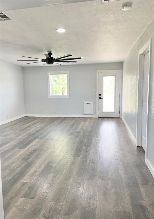 1304 W Walnut St, Tecumseh, OK 74873 - unfurnished room featuring a smoke detector, ceiling fan, dark wood-type flooring, and a textured ceiling