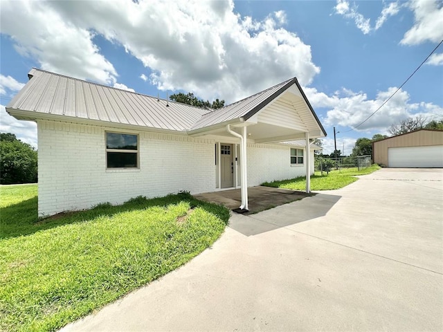 1304 W Walnut St, Tecumseh, OK 74873 - single story home featuring a front lawn, a metal roof, brick siding, a garage, and an outdoor structure