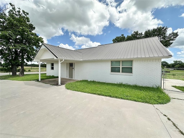 1304 W Walnut St, Tecumseh, OK 74873 - ranch-style house featuring a metal roof, brick siding, and a front yard