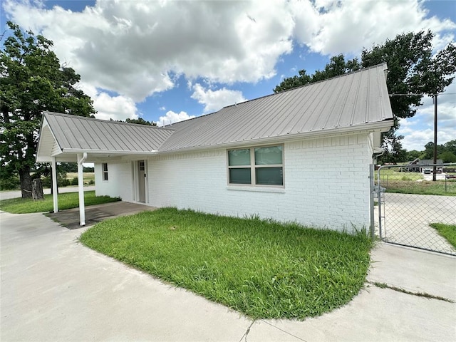 1304 W Walnut St, Tecumseh, OK 74873 - ranch-style home with a metal roof, brick siding, and a gate