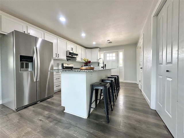 1304 W Walnut St, Tecumseh, OK 74873 - kitchen featuring stainless steel fridge with ice dispenser, range, dark wood finished floors, recessed lighting, and a center island with sink