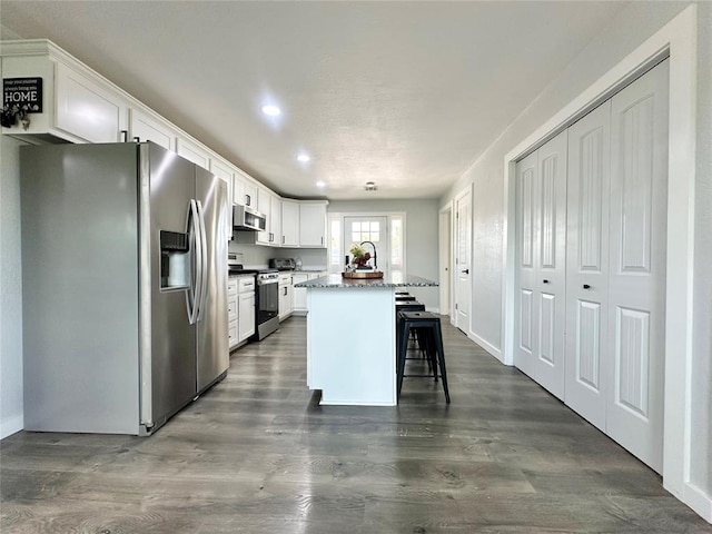 1304 W Walnut St, Tecumseh, OK 74873 - kitchen with stainless steel appliances, a center island, white cabinets, recessed lighting, and dark wood-type flooring