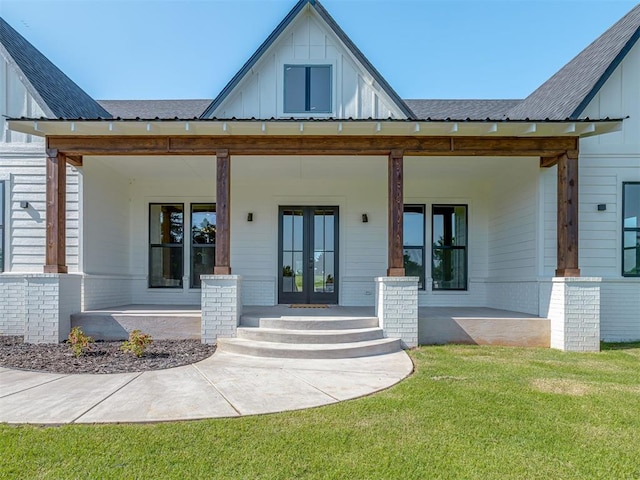 5812 Cimarron Mnr, Guthrie, OK 73044 - doorway to property with french doors, board and batten siding, a lawn, and brick siding