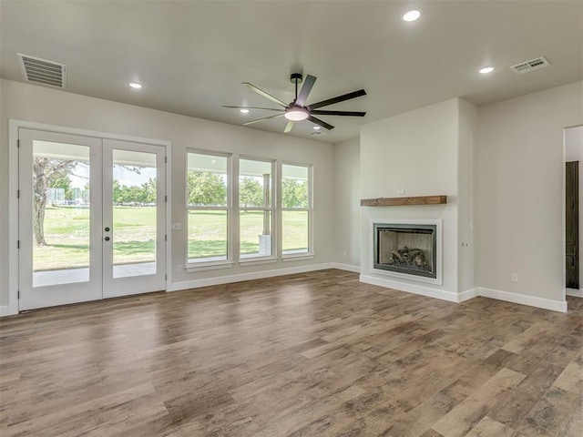 5812 Cimarron Mnr, Guthrie, OK 73044 - unfurnished living room featuring french doors, a ceiling fan, wood finished floors, a fireplace, and recessed lighting